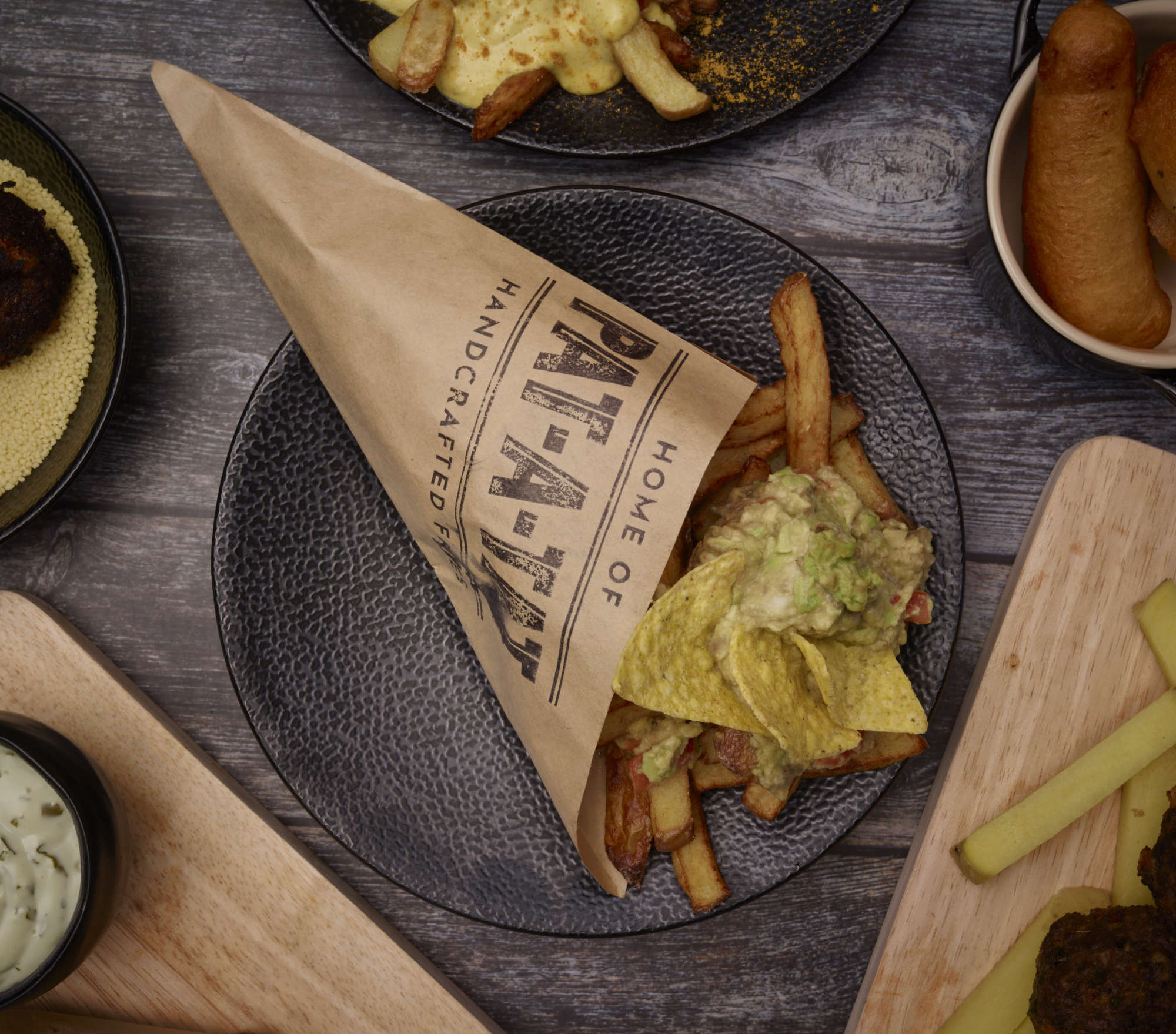Loaded fries in branded paper cone, overhead flatlay